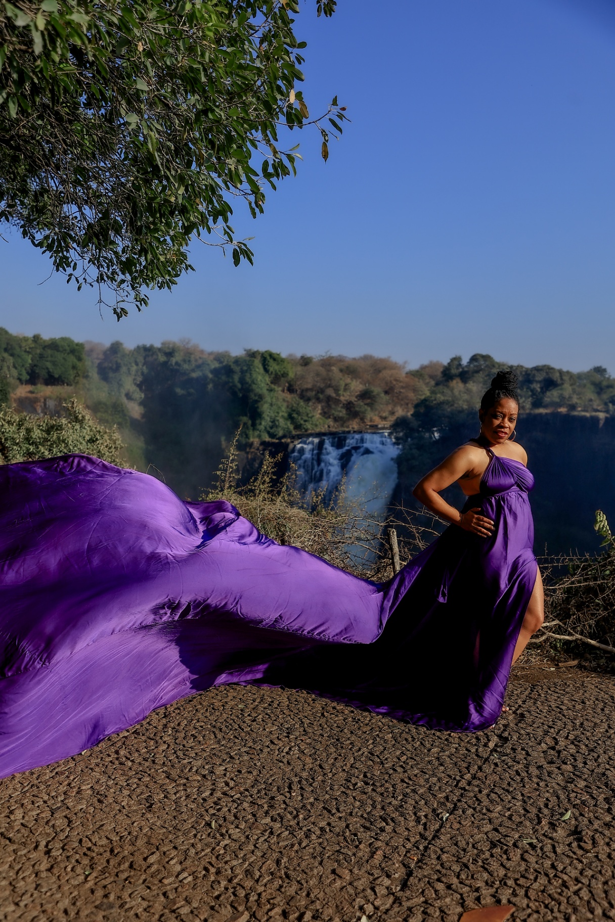 Purple satin flying dress trailing toward the mist of Victoria Falls