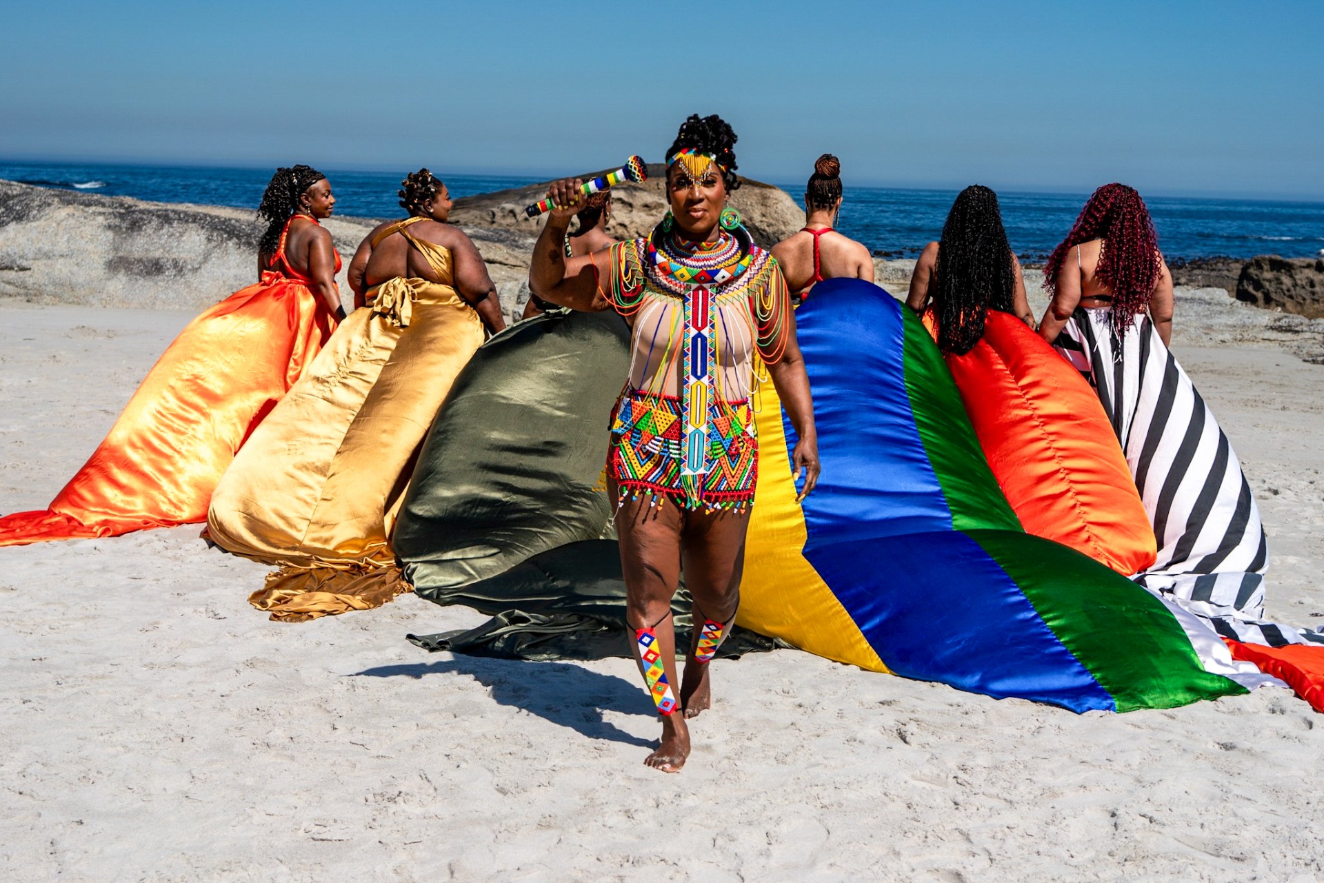 A collection of colourful flying dresses on the Cape Town shoreline
