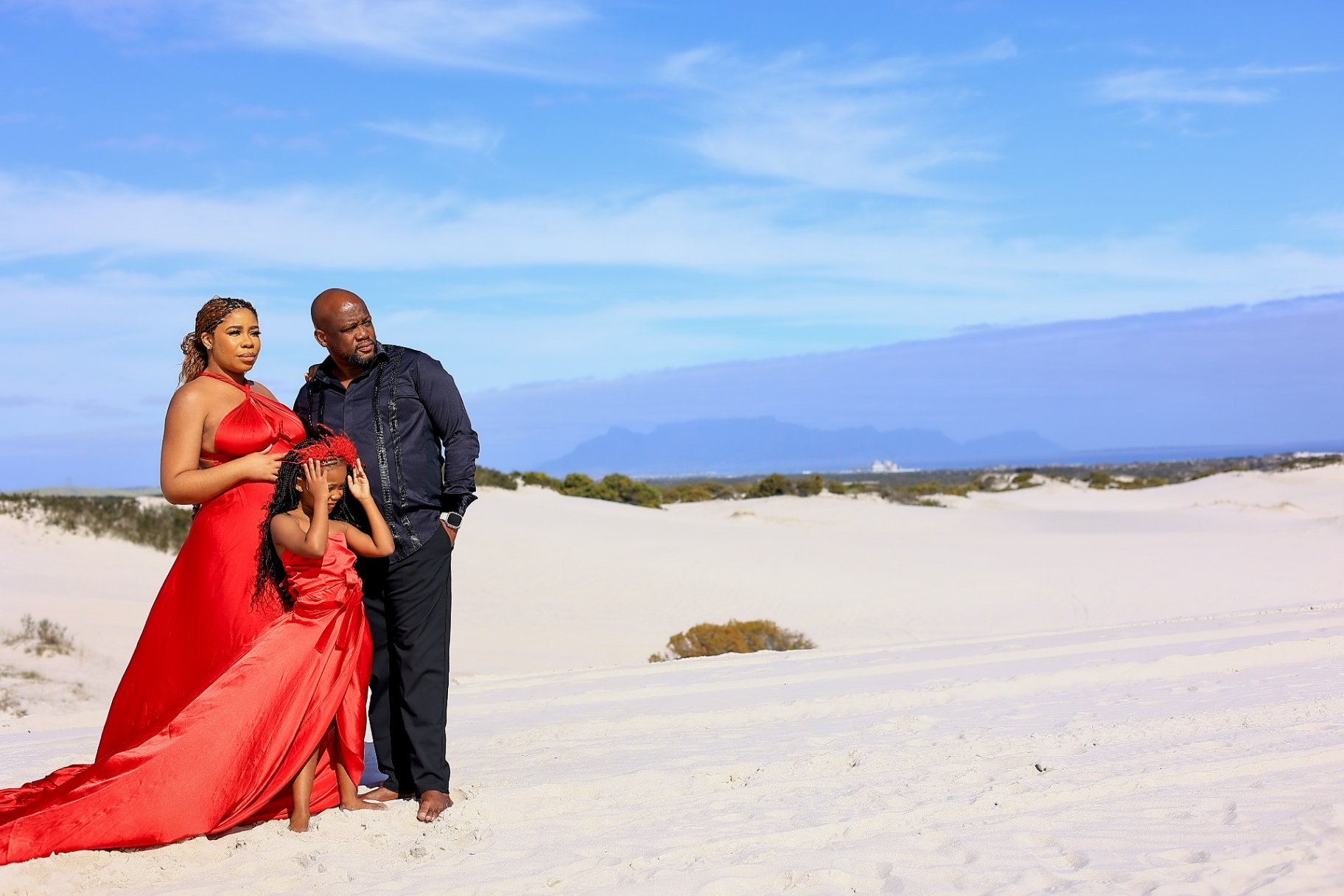Family portrait in red flying dresses on the white Cape Town dunes